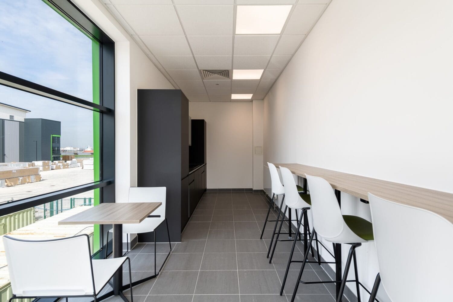 Modern staff kitchen with relaxed seating and poseur bar and stools in an industrial fit out project.