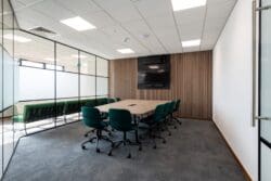 Boardroom design with bespoke boardroom table, attractive chairs and wood panel feature wall with integrated TV and sound bar.