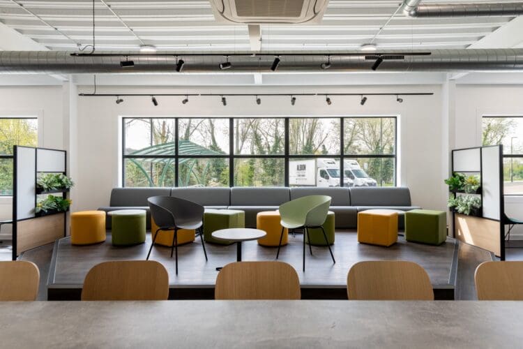Elevated seating area with banquet seating and coffee tables. Complimentary branding colours.
