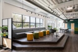 open plan break out area at Albion Fine Foods recent office fit out at their industrial warehouse for Rap Interiors. Furniture solutions show elevated break out area with soft furnishings in company branding colours of grey, green and yellow.
