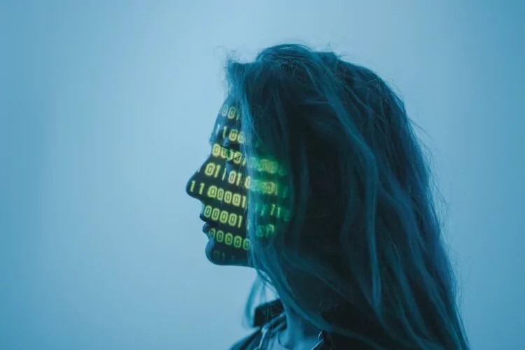 Profile of femaile face with computer data projected onto her face, focusing on artificial intelligence in the work space.