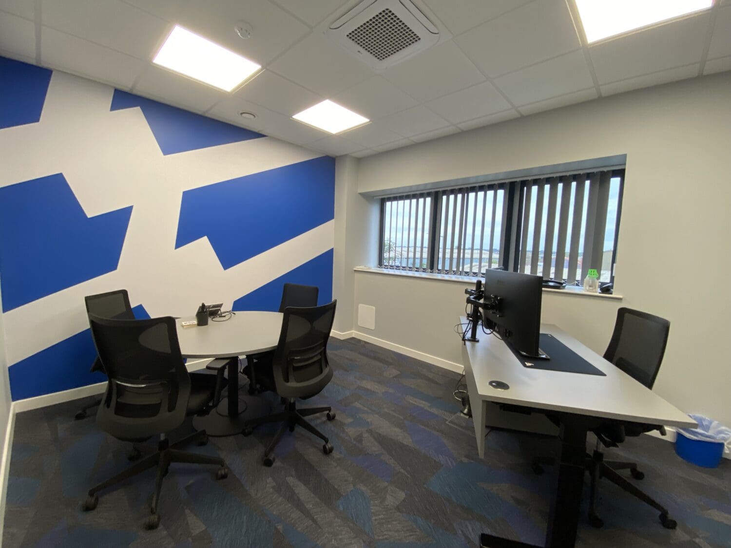 Office refurbishment with company logo feature wall and office furniture.