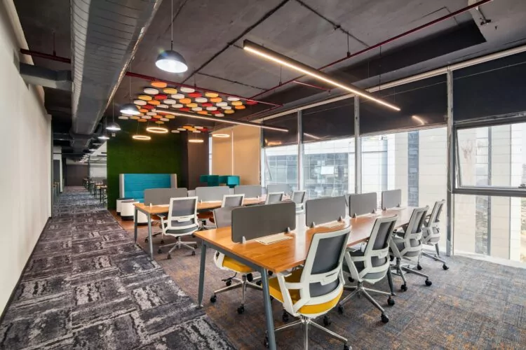 Modern open plan office interior design scheme using patterned carpet and wooden desking.