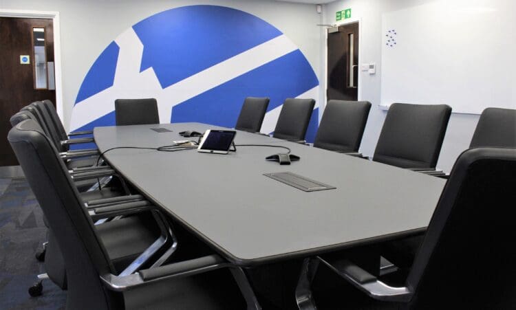 Bespoke-boardroom-table-in corporate-office-interior-design-scheme-with-company -logo-feature-wall-behind