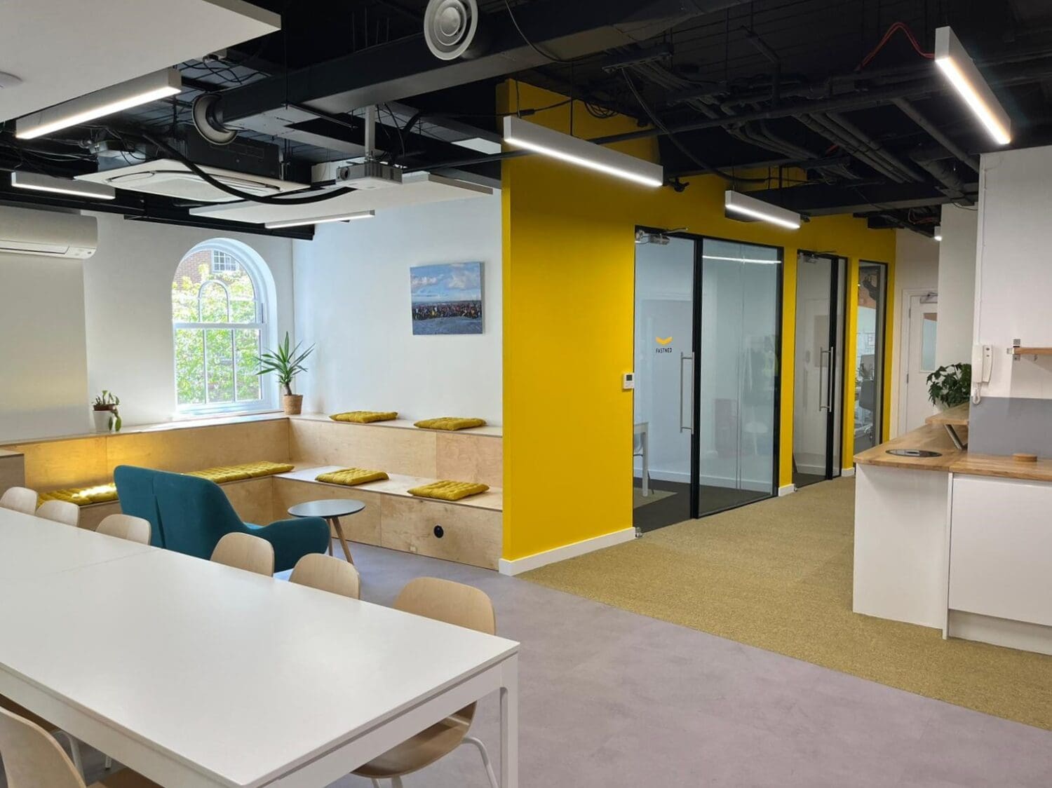 Office refurbishment London with breakout space including corporate branded colours.
