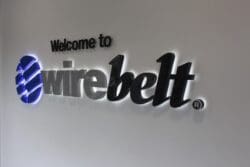 Wire Belt company logo in perspex stand off wall graphics in an office interior design scheme.