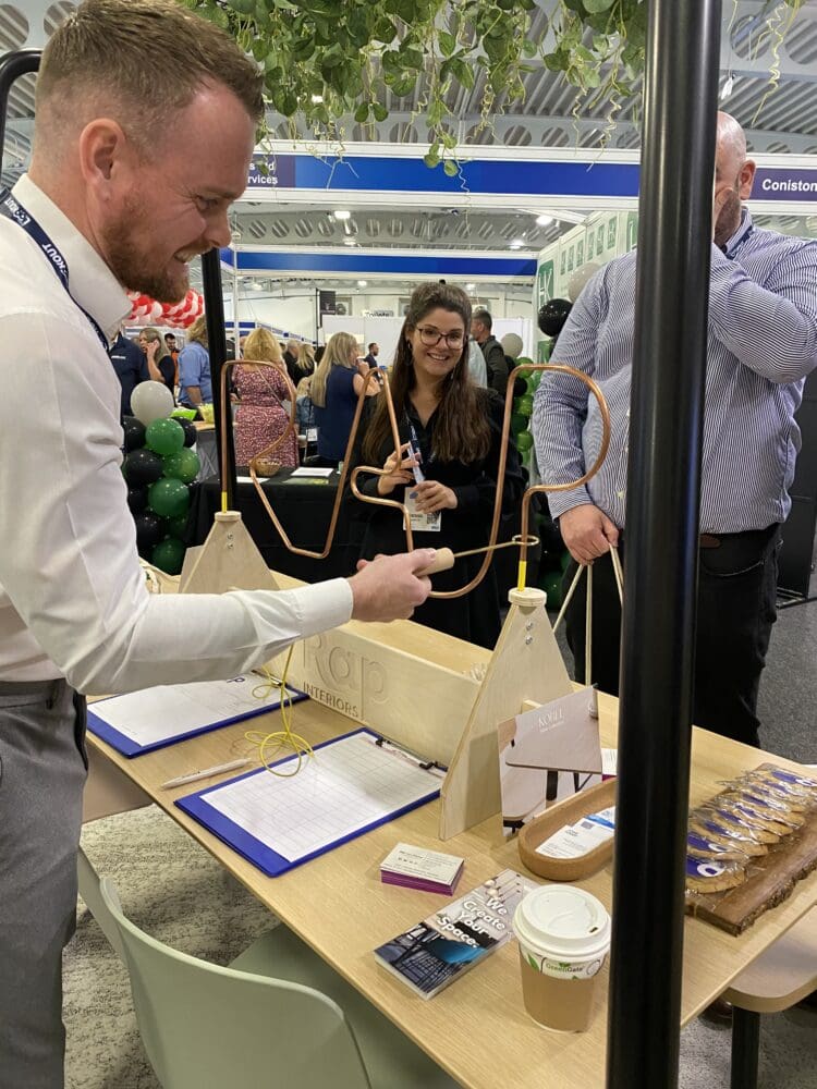 man playing wire buzz game at the rap interiors stand