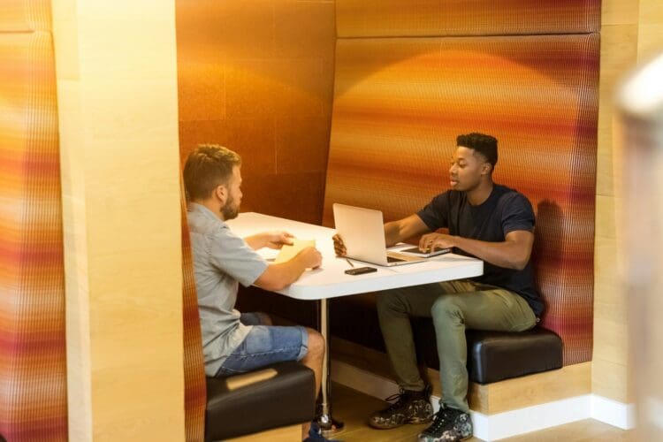 Colleagues meeting in office booth.