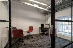 Glazed meeting room with meeting table and task chairs.