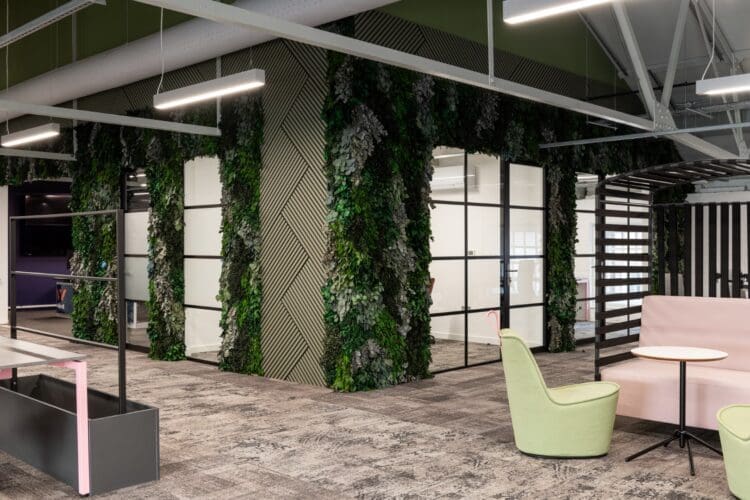 Large biophilic feature wall with preserved foliage and olive green slatted timber.