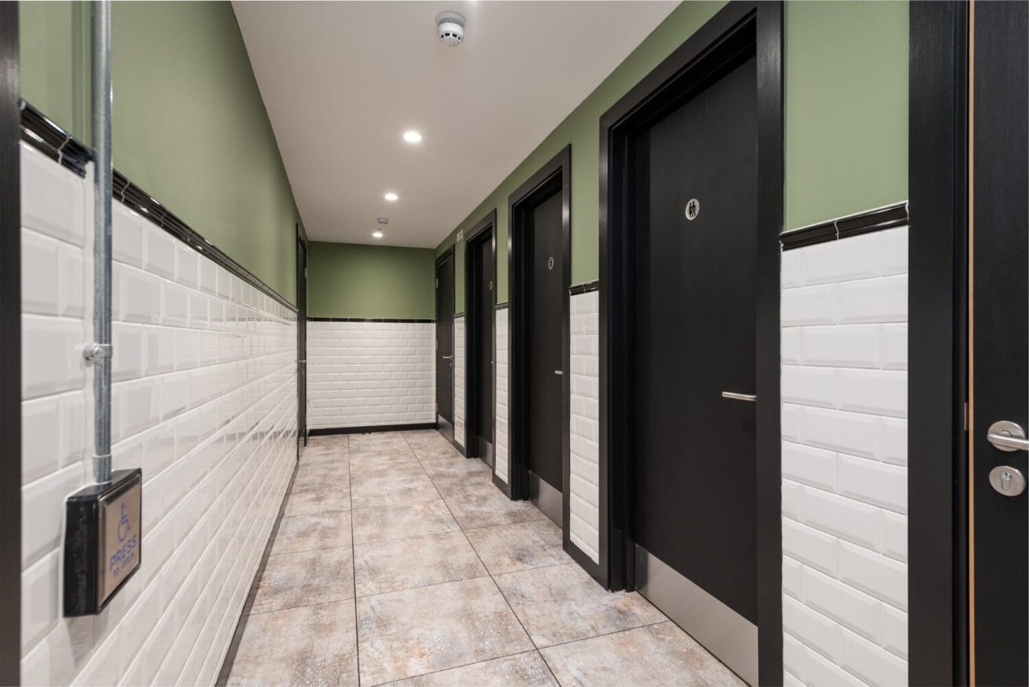 Office washroom design with white tiles and black border tiles.