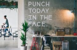 Inspirational quote feature wall in an industrial themed office design.