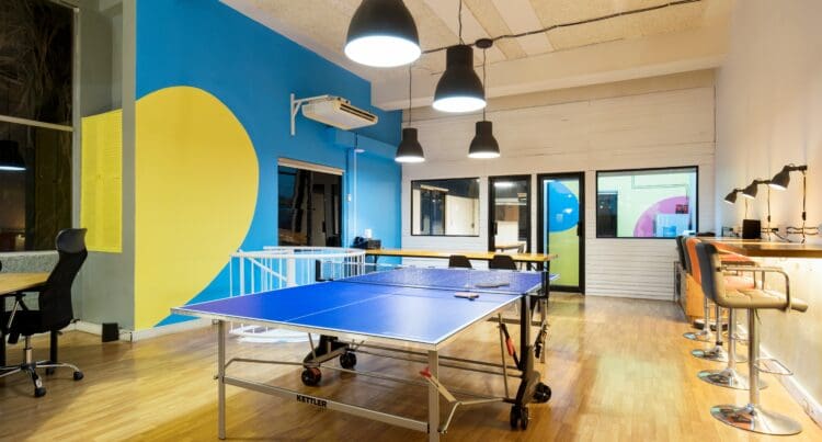 Office breakout space with table tennis table and pendant lighting.