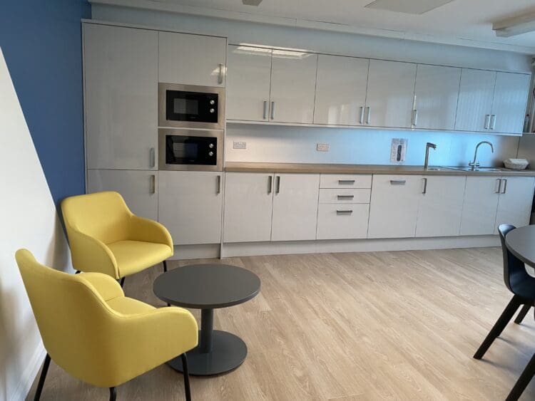 Grey modern teapoint and yellow soft seating in London school refurbishment project.