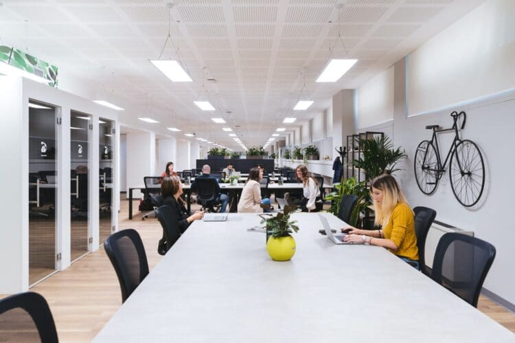 Colleagues interacting in hybrid office layout.
