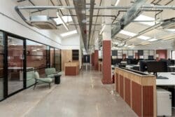 Modern open plan office with terracotta walls and waiting area.