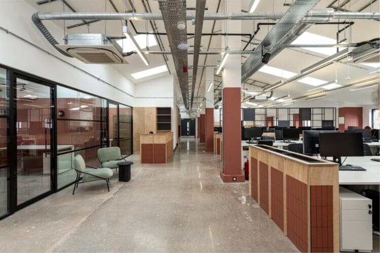 Modern open plan office with terracotta walls and waiting area.