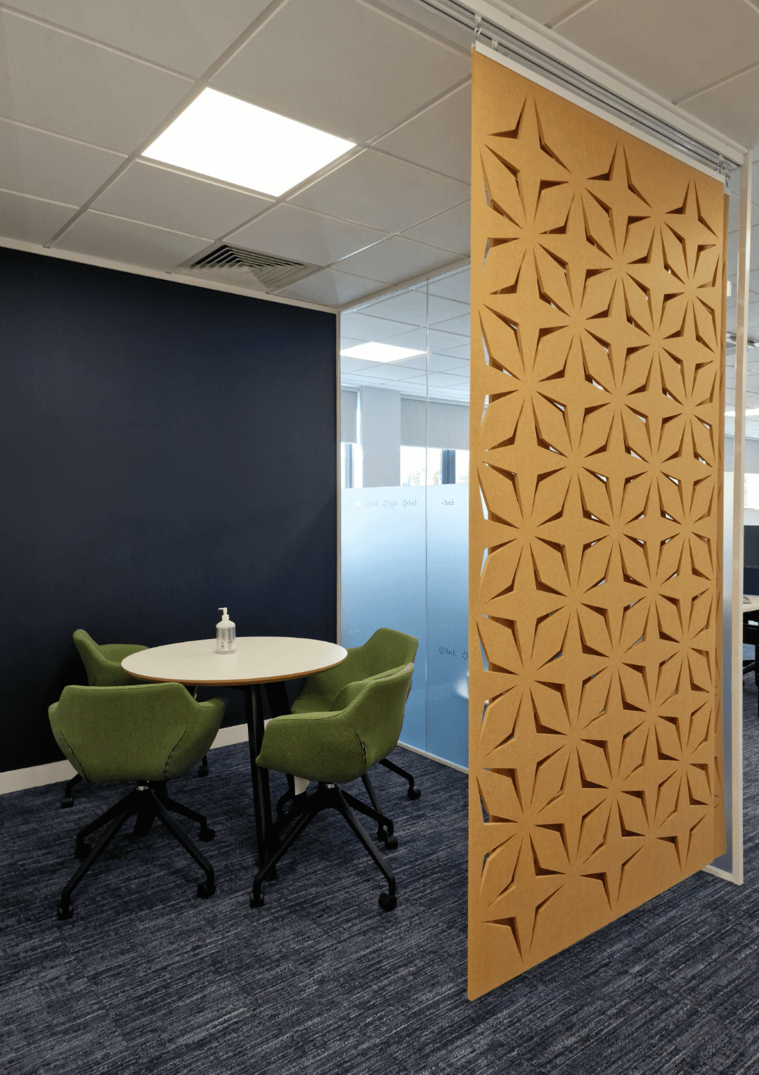 Informal office meeting space with sliding acoustic panel.