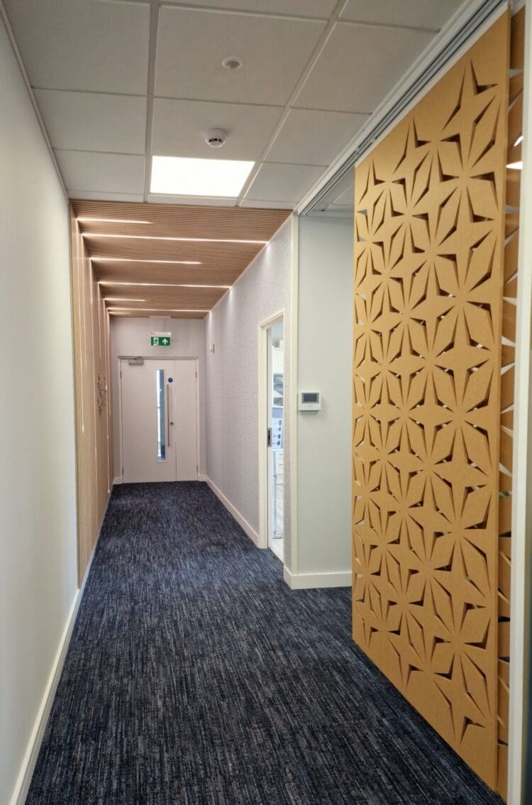 Office entrance with timber slat wall with integrated lighting and sliding acoustic panel.
