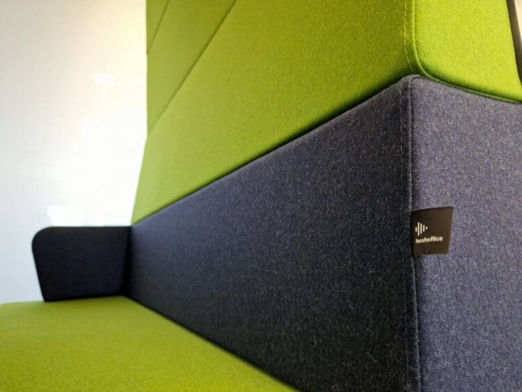 Office meeting booth with blue and green upholstered seat.