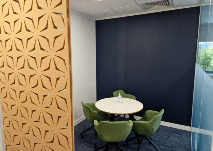 Office meeting space with acoustic sliding panels and upholstered meeting chairs.