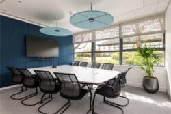 Corporate office meeting room with modern furniture solutions and feature acoustic pendants.