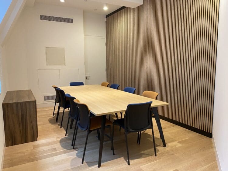 Modern boardroom interior design with wooden slat feature wall.