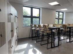 Dining tables and high curved stools in school refurbishment project.