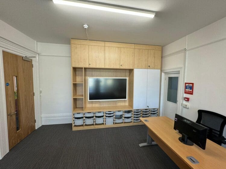 Bespoke media wall with seamless tidy storage solution for modern classroom design and refurbishment.