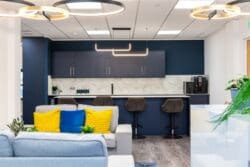 Client event space in office fit out works with feature lighting and soft seating.