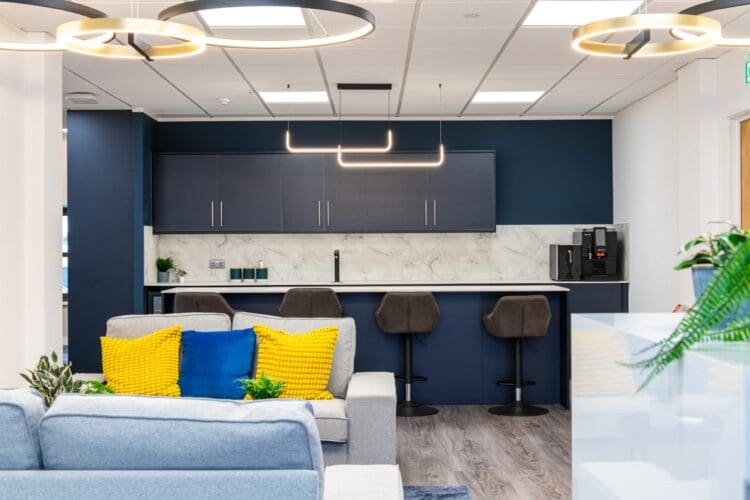 Client event space in office fit out works with feature lighting and soft seating.