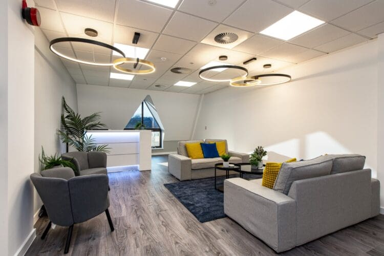 Office reception area in Cat B office fit out project with statement lighting and bespoke desk.