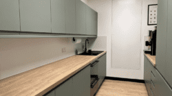 Office tea point refurbishment with sage green units and wood effect worktop.
