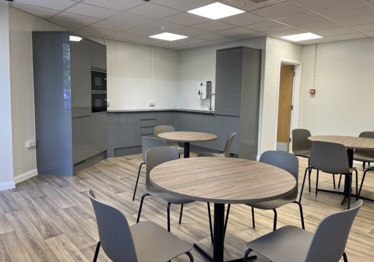 Office break out space refurbishment with modern gloss grey kitchen and dining facilities.