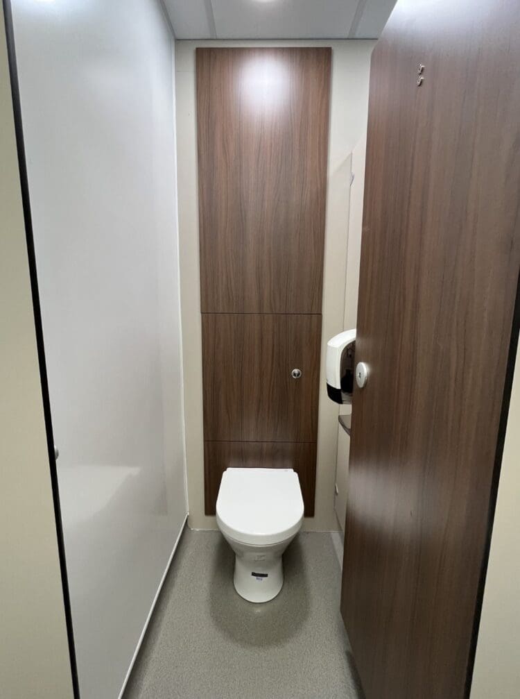 Washroom design with wood effect panel and cubicle door.