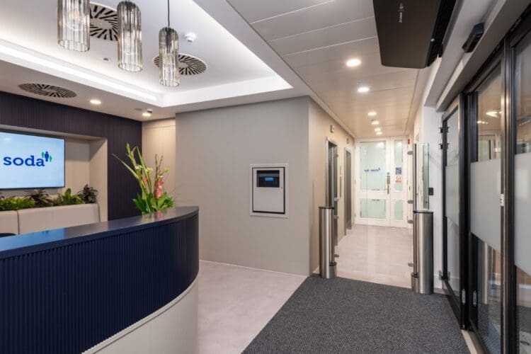 Corporate London office reception area with glazed security gates.