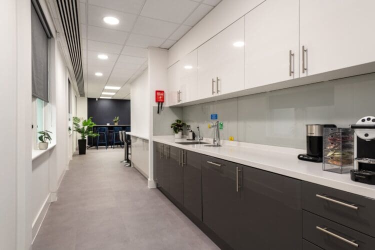 Modern office tea point with gloss cupboards and breakout space.