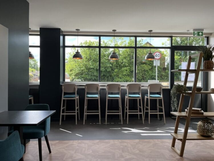 Breakfast bar seating along shop front in coffee shop interior design